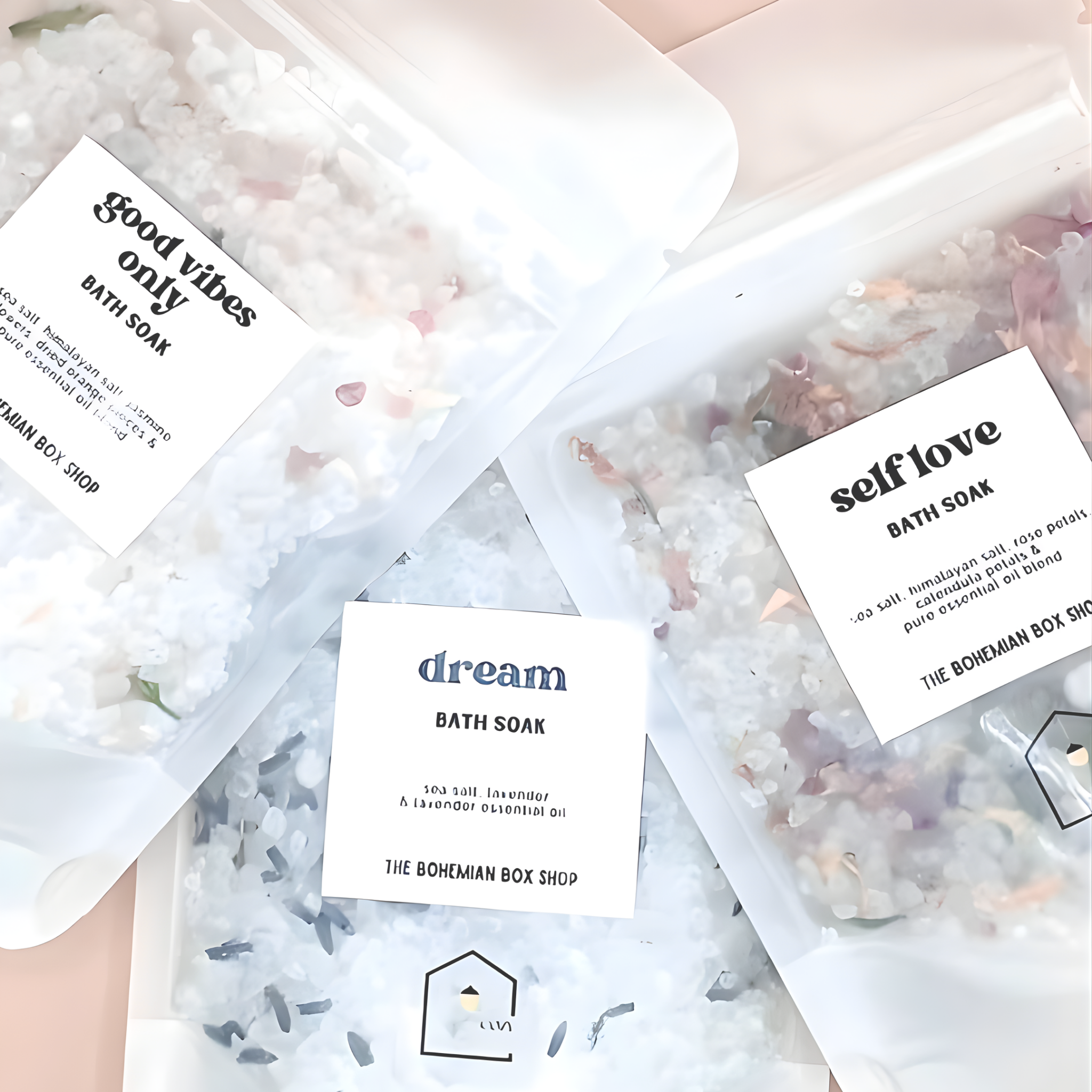 Bath soaks with labeled packaging on a light pink background