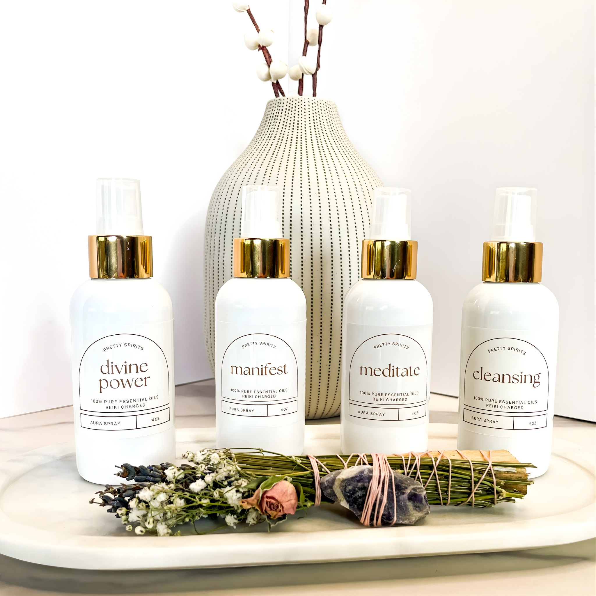 Four white bottles with gold caps on a white surface with decorative elements.