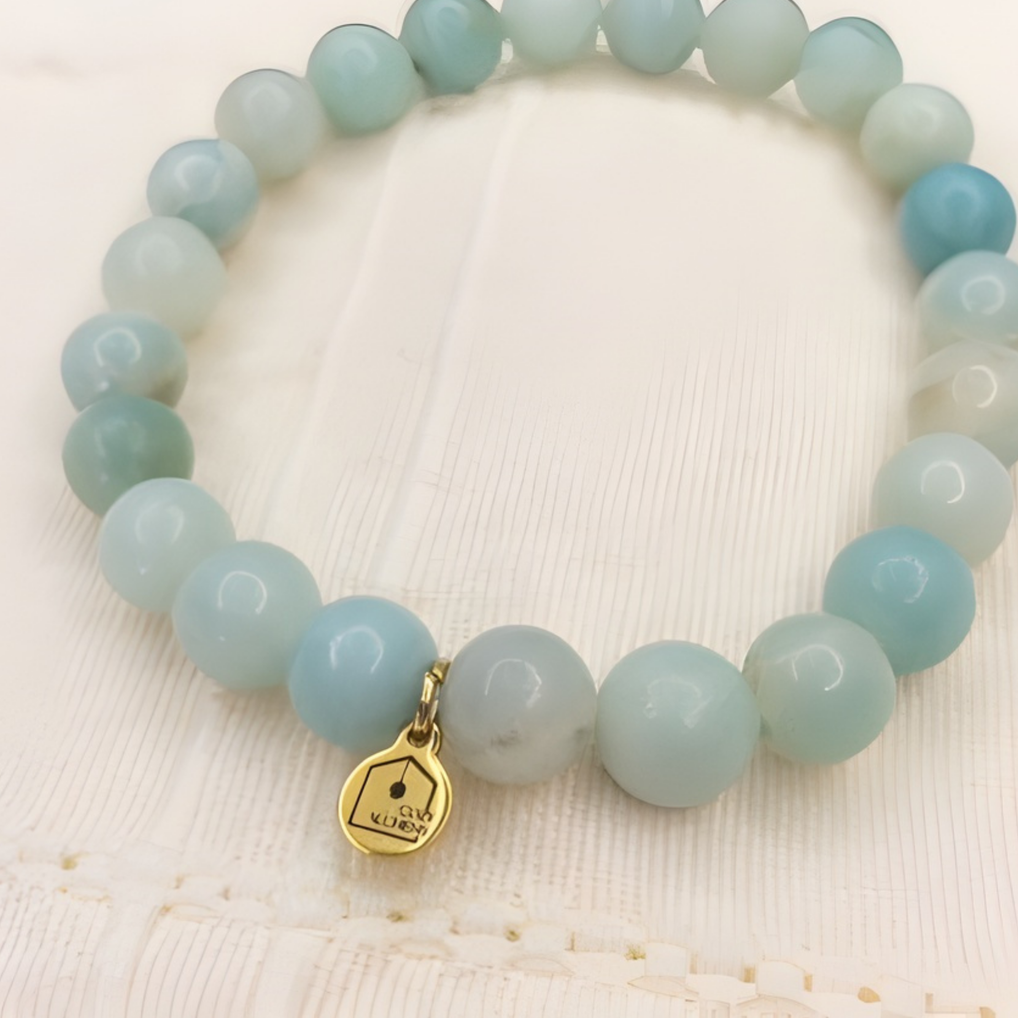 amazonite bead bracelet with charm on linen cloth