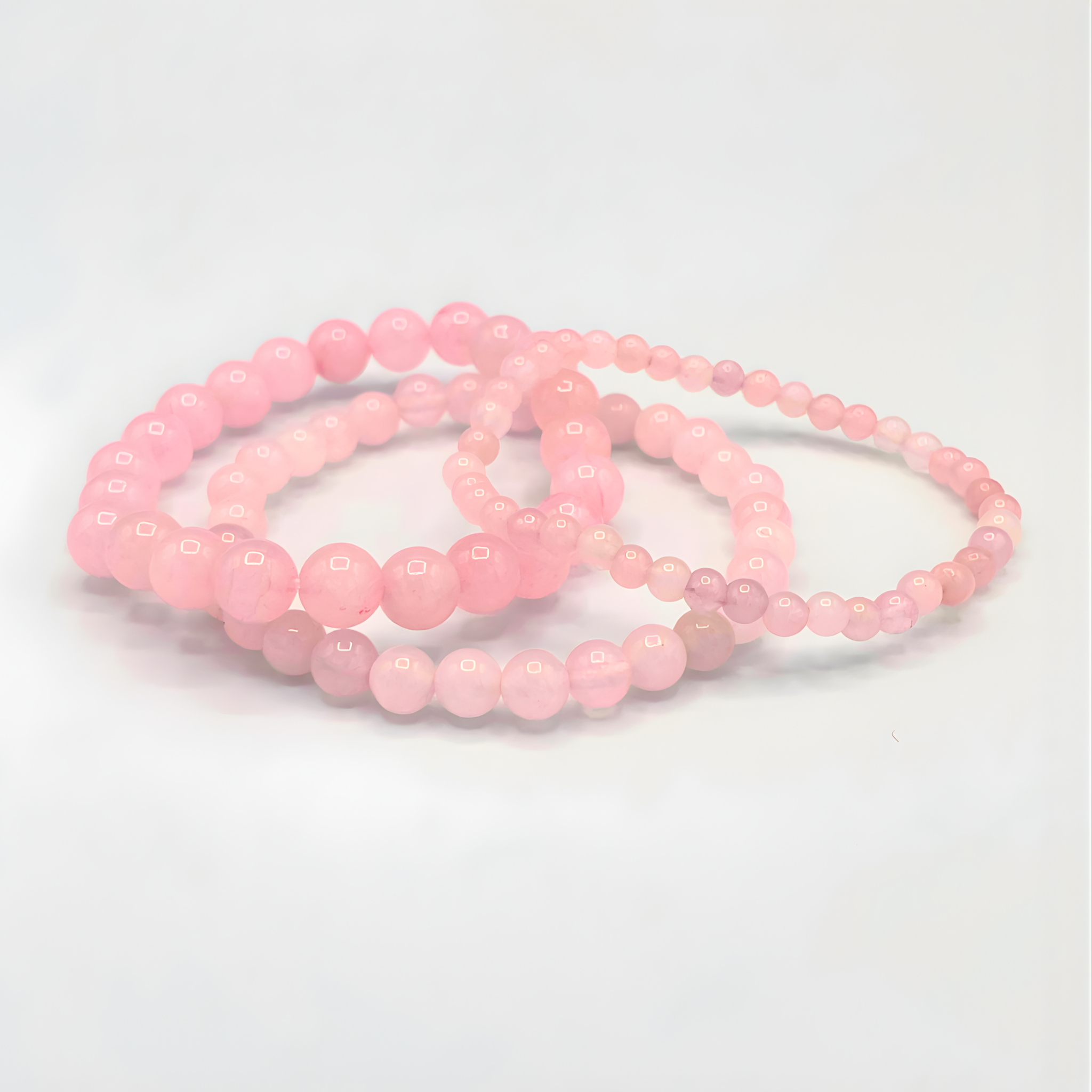 Set of pink beaded bracelets on a light gray background