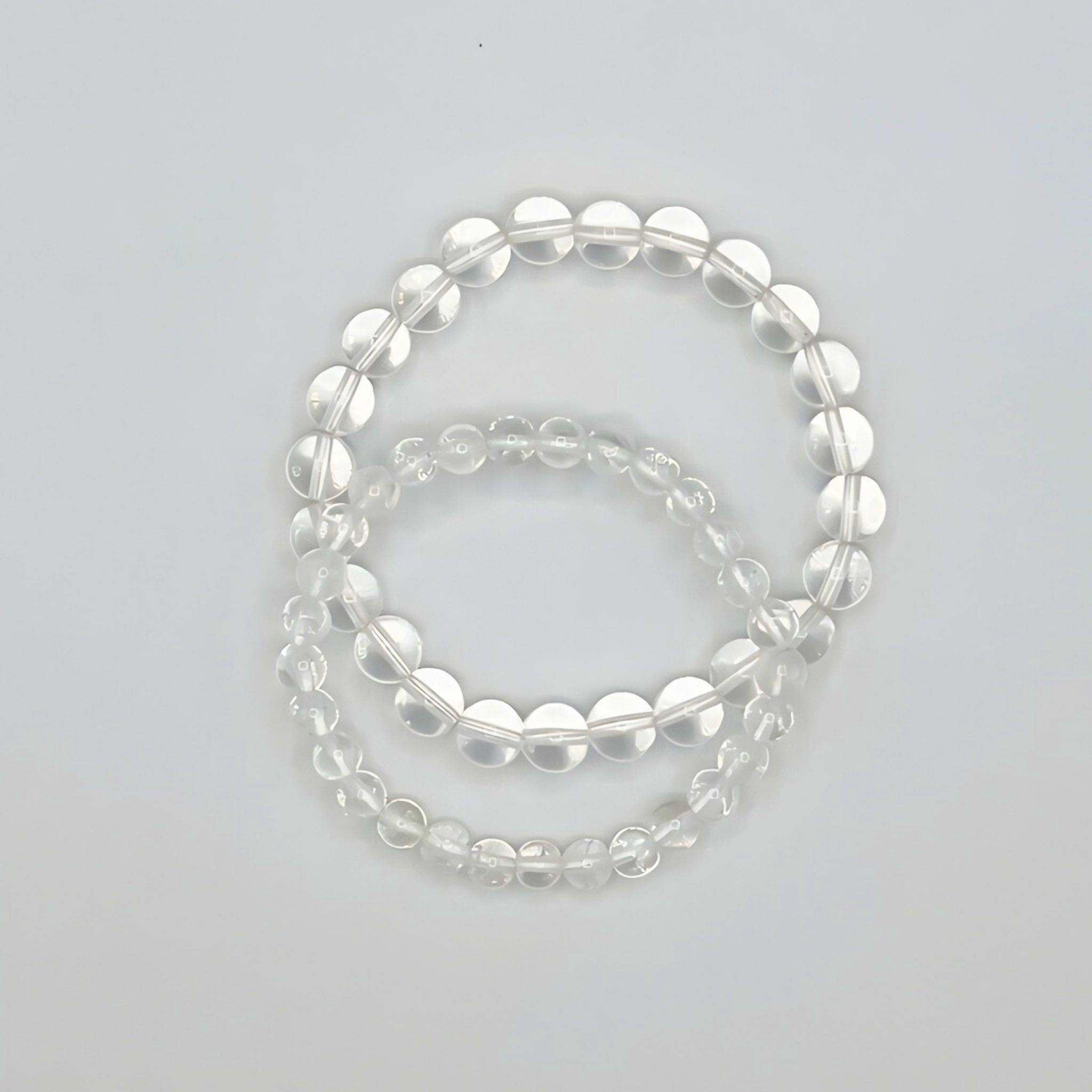 Set of clear beaded bracelets on a light gray background