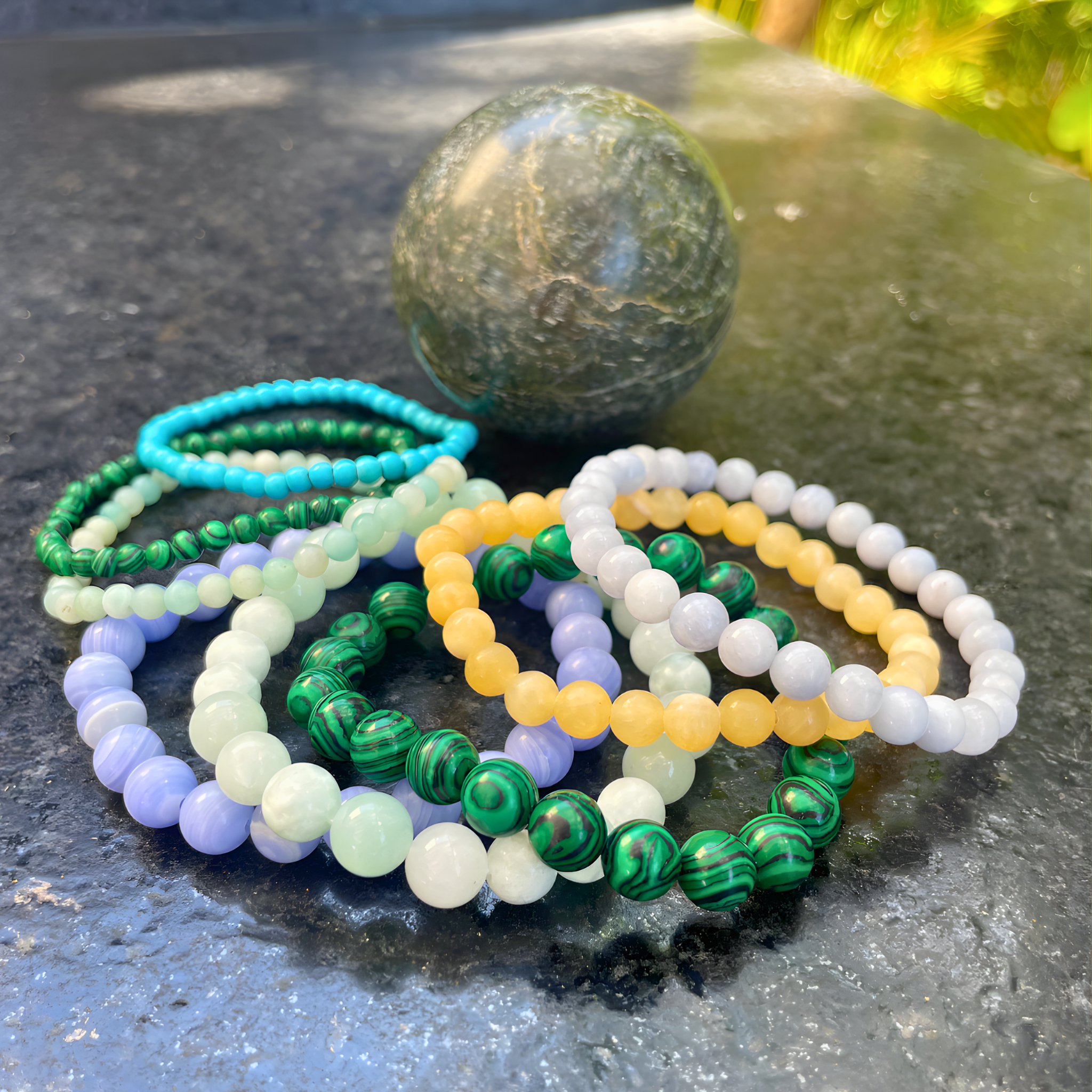 Set of colorful beaded bracelets on a dark surface with a marble-like texture.