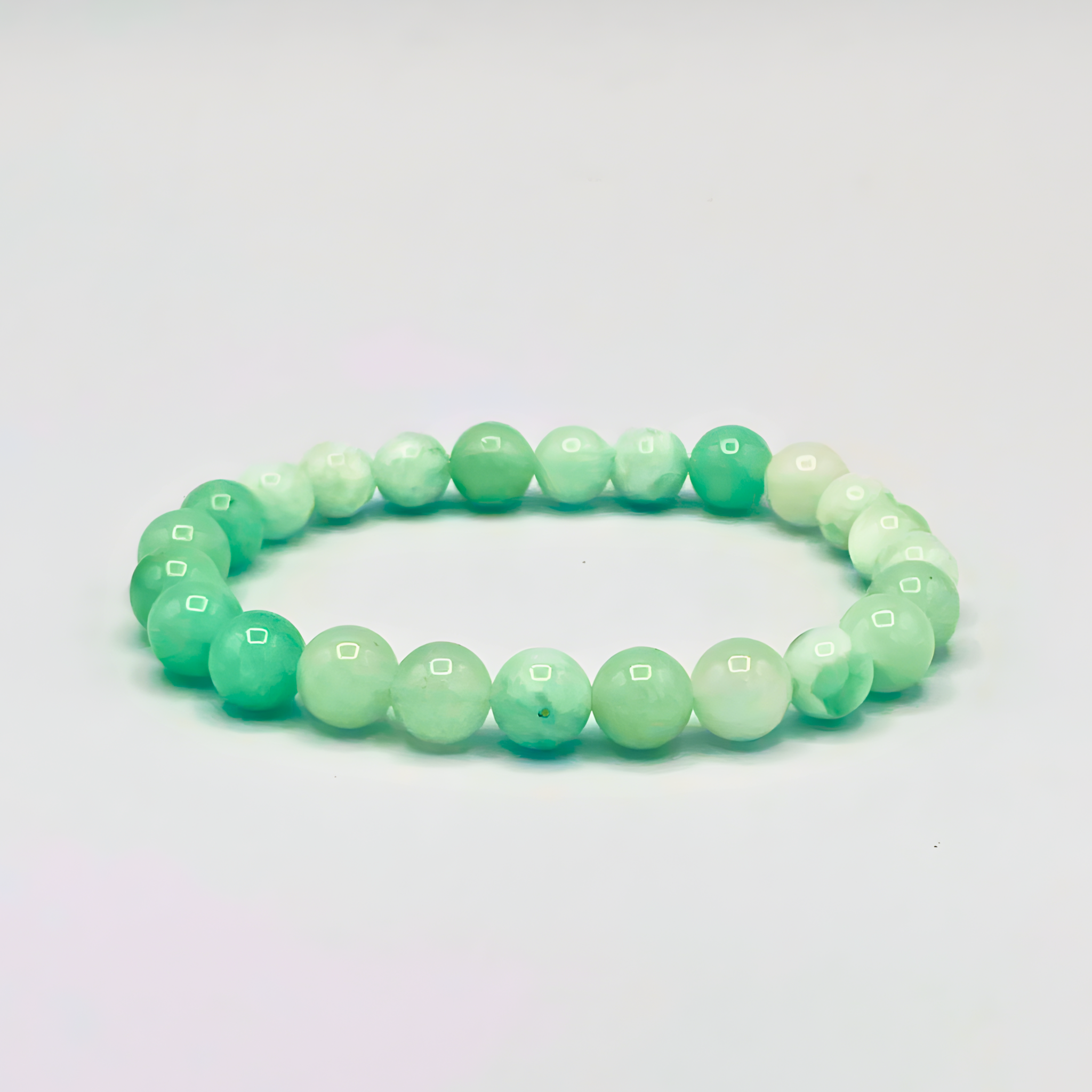 Green beaded bracelet on a light gray background