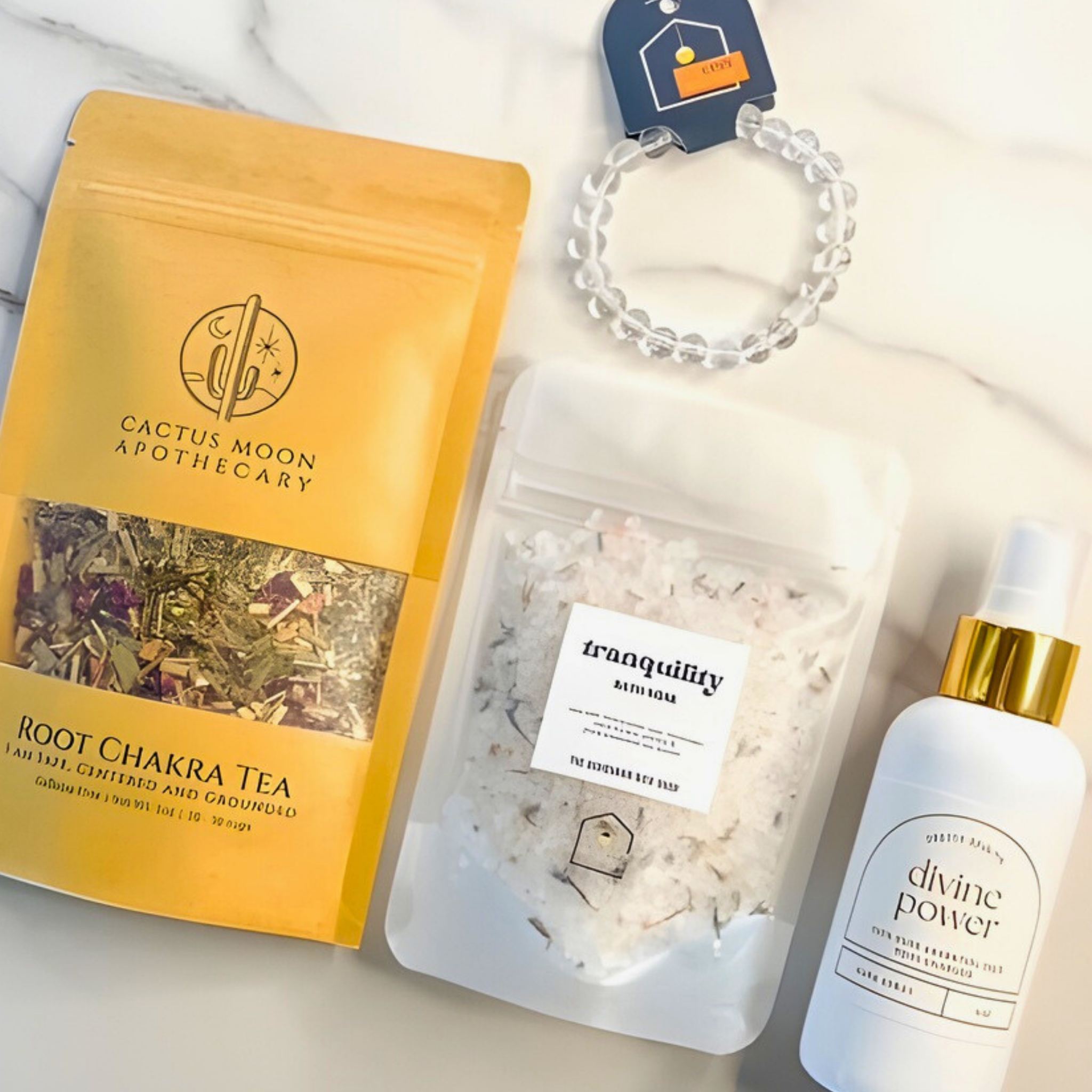 Cactus Moon Apothecary Root Chakra Tea, Tranquility bath salts, and Divine Power oil on a white background