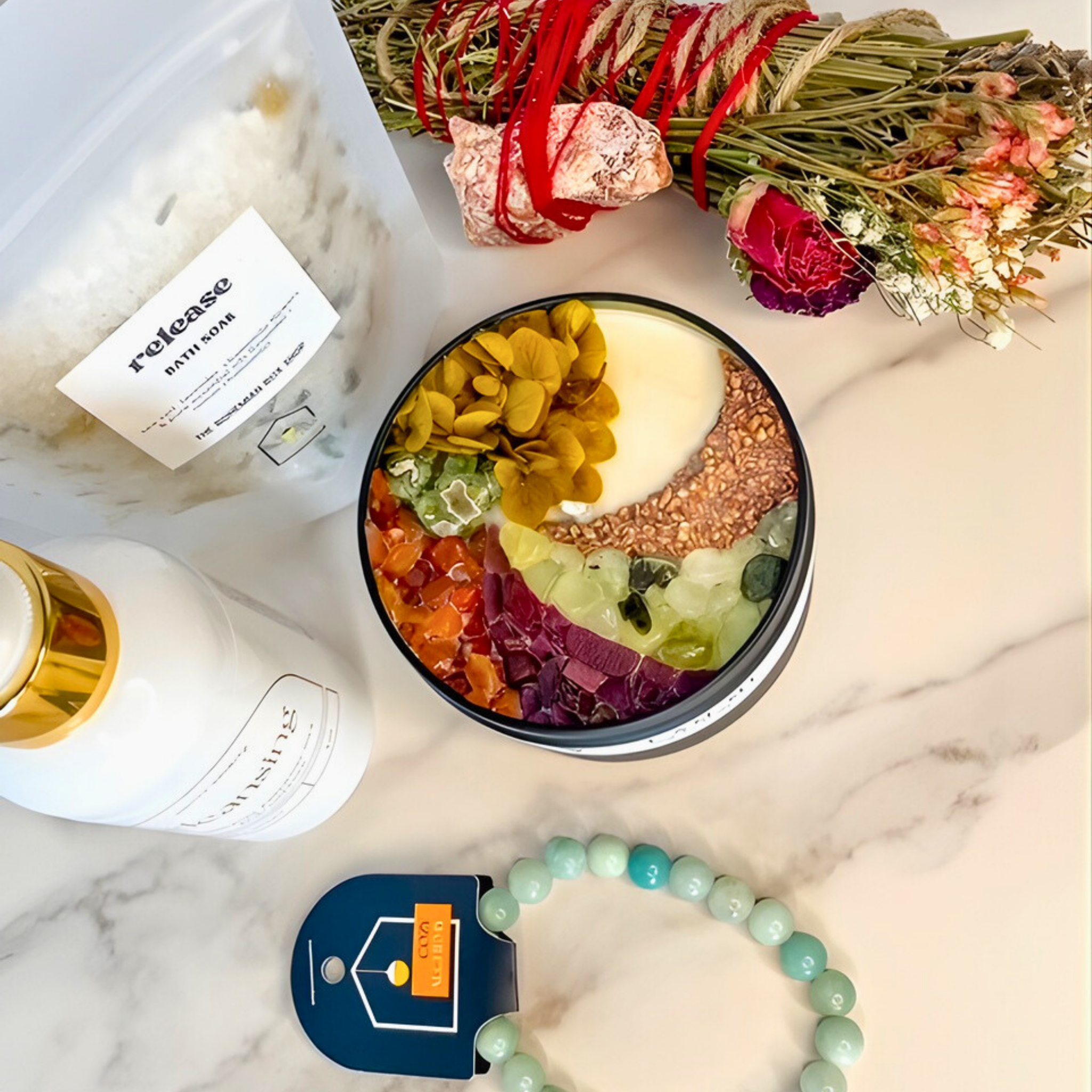 Bowl with layered ingredients, bottle, bracelet, and decorative elements on a marble surface