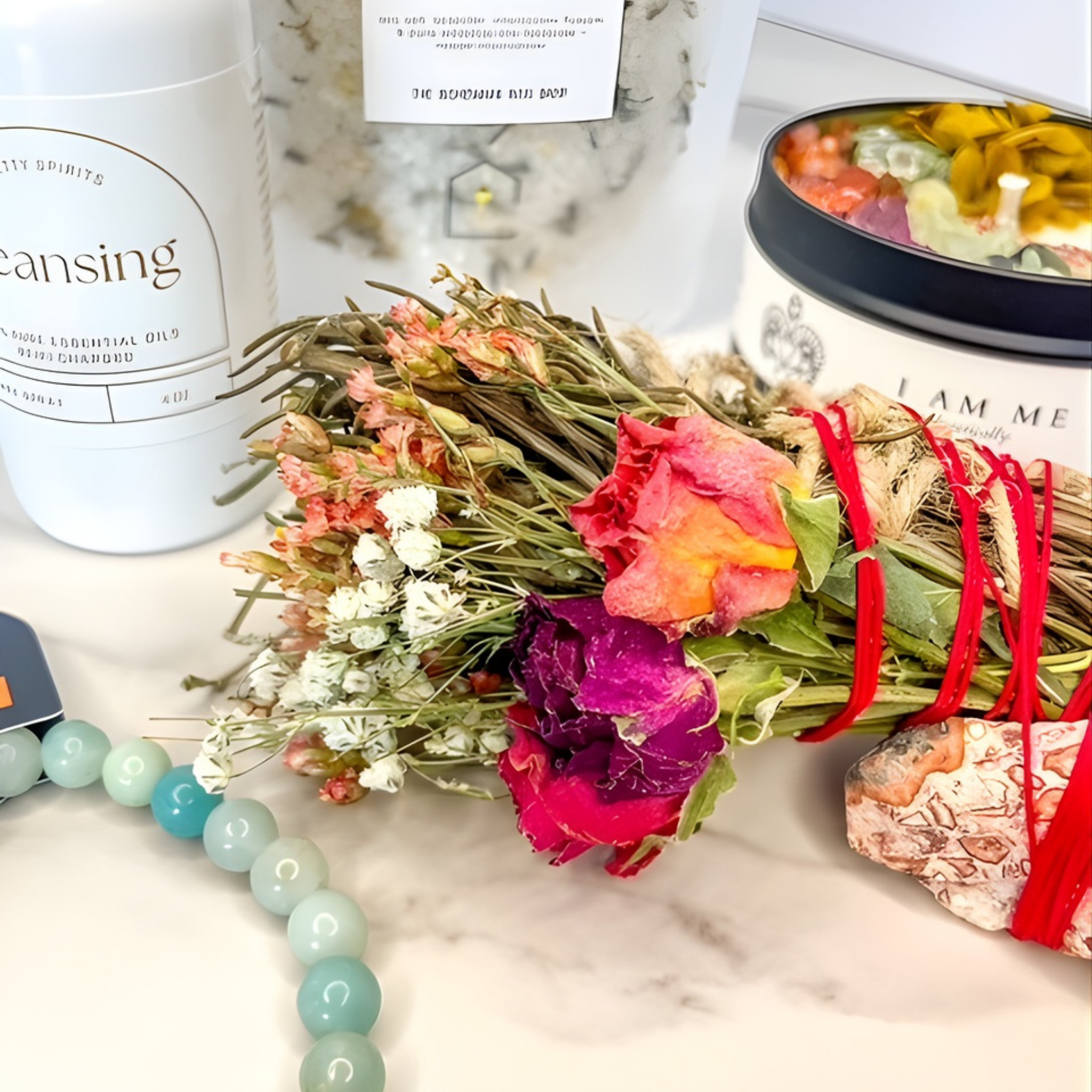 Bouquet of flowers with red ribbons on a marble surface with wellness products in the background.
