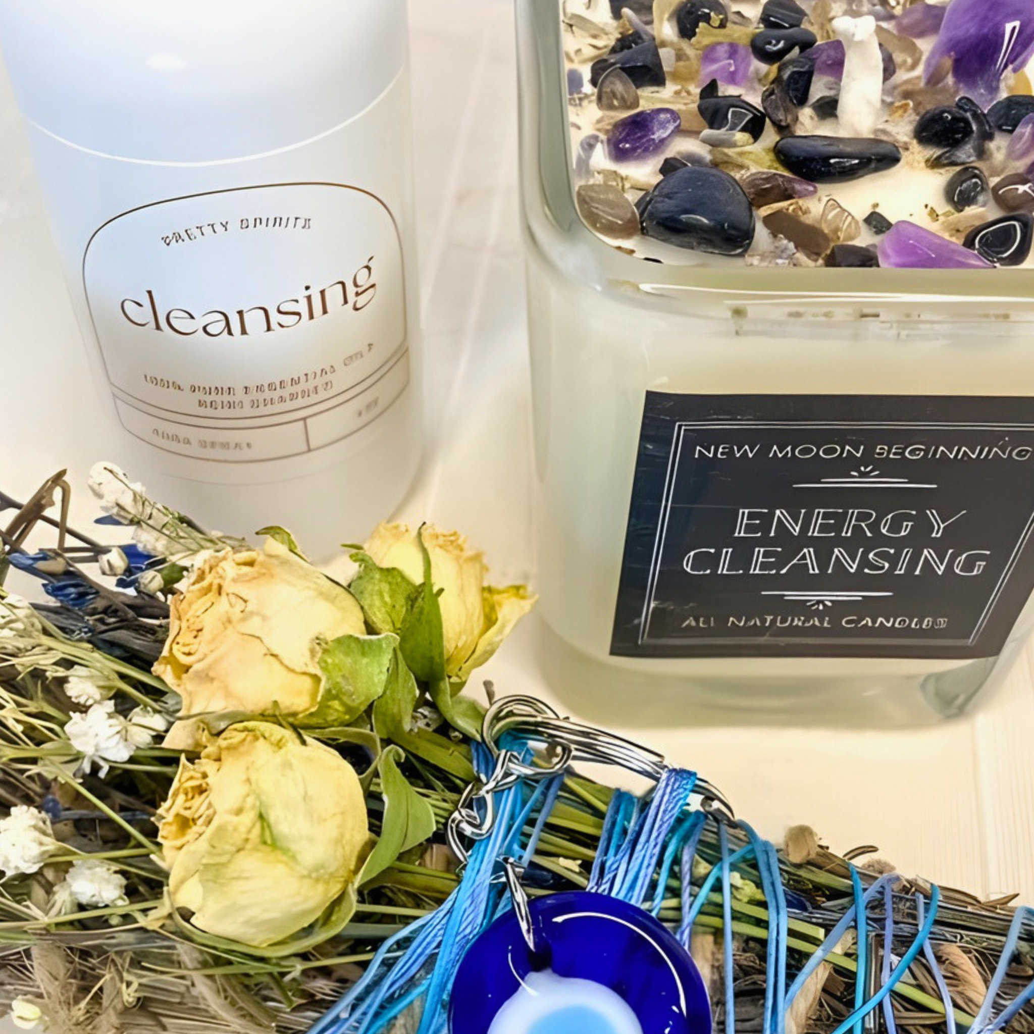 Candle labeled 'Energy Cleansing' with flowers and a bottle labeled 'Pretty Spirits Cleansing' on a white background.