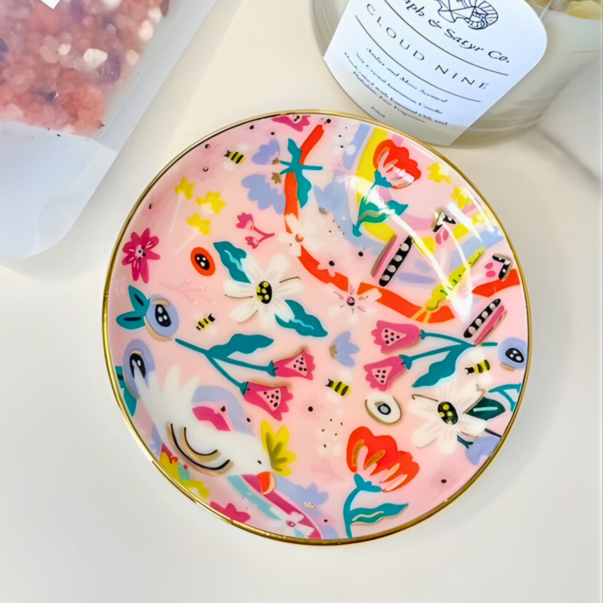 Colorful ceramic plate with floral and abstract designs on a white surface.