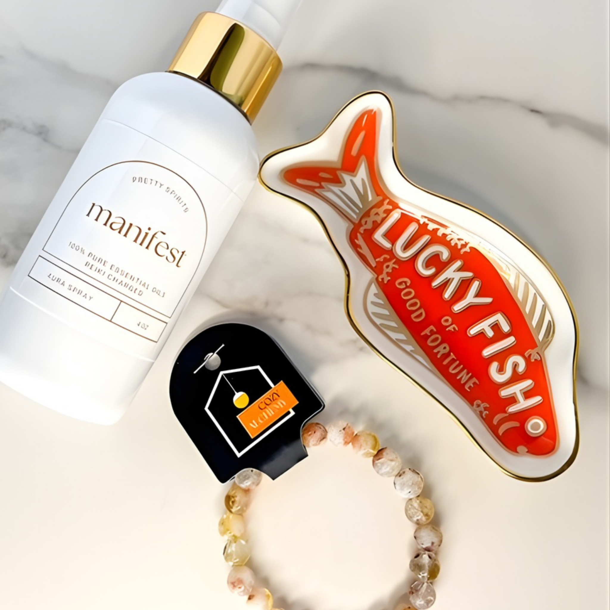 Manifest product, Lucky Fish charm, and bracelet on a marble surface