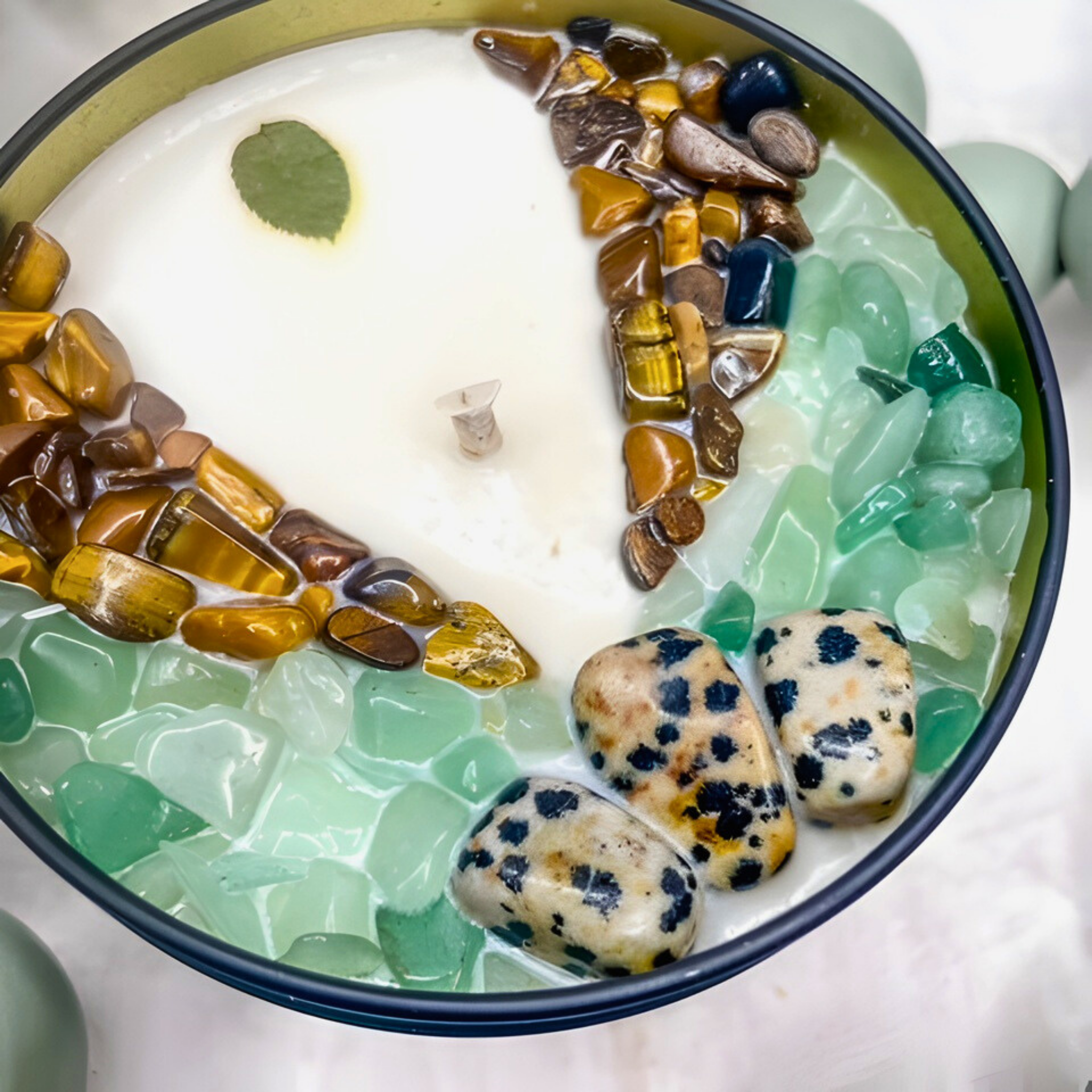 Decorative bowl with stones and a leaf on a white background