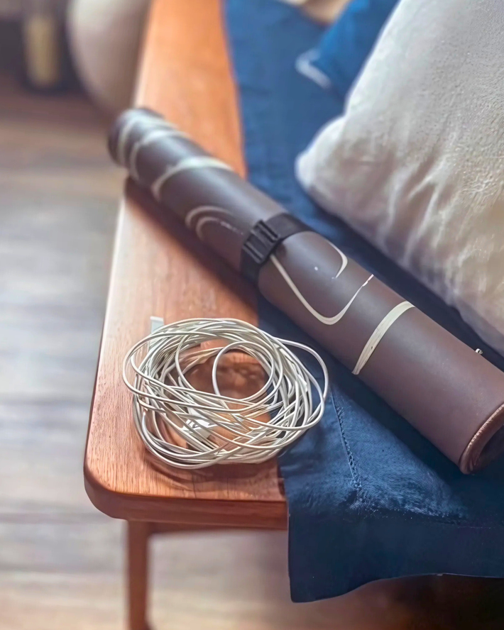 Roller and coiled wire on a wooden surface with a blurred background