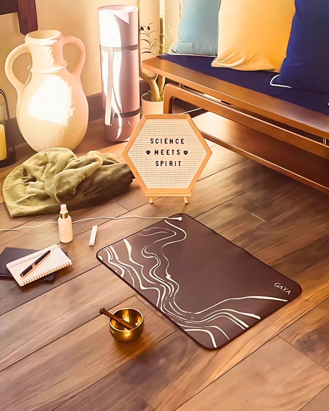 Yoga mat on a wooden floor with decor items and a sign reading 'Science Meets Spirit'.
