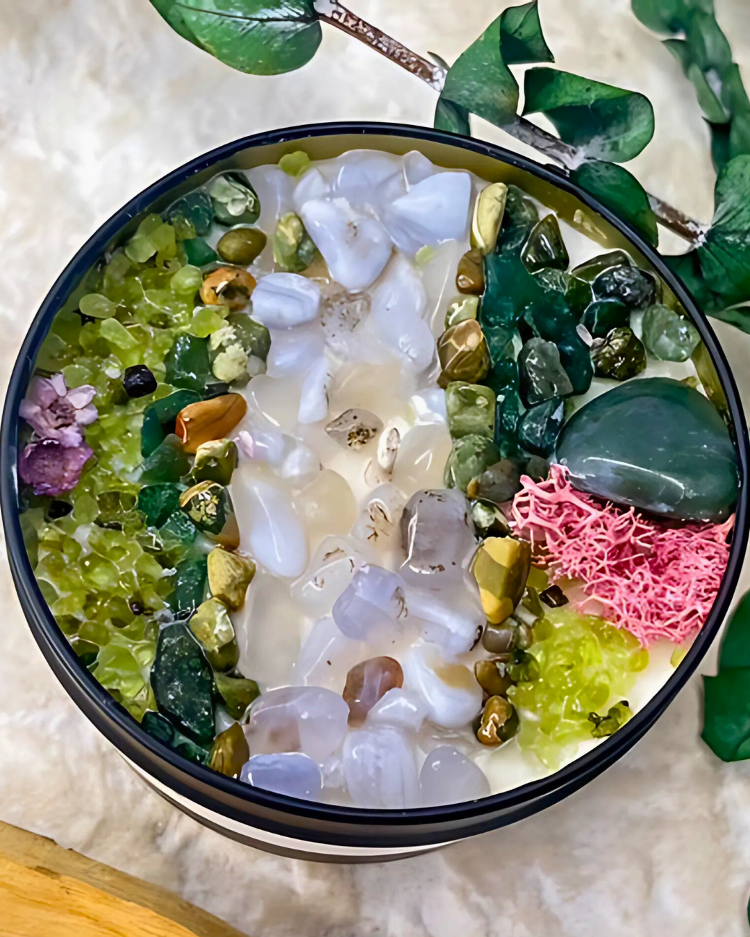 Decorative bowl with colorful stones and plants on a light background