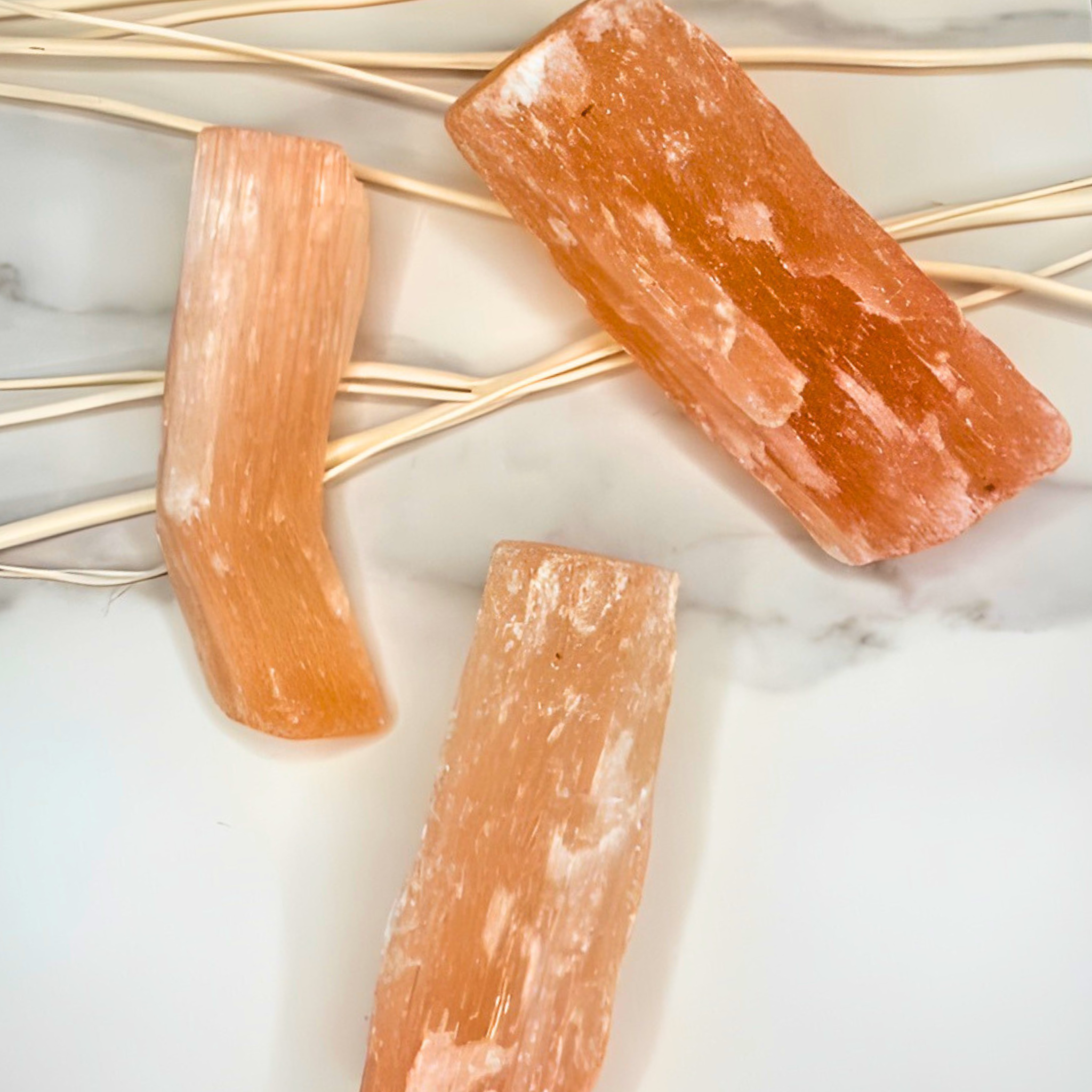Three orange crystal bars on a marble surface