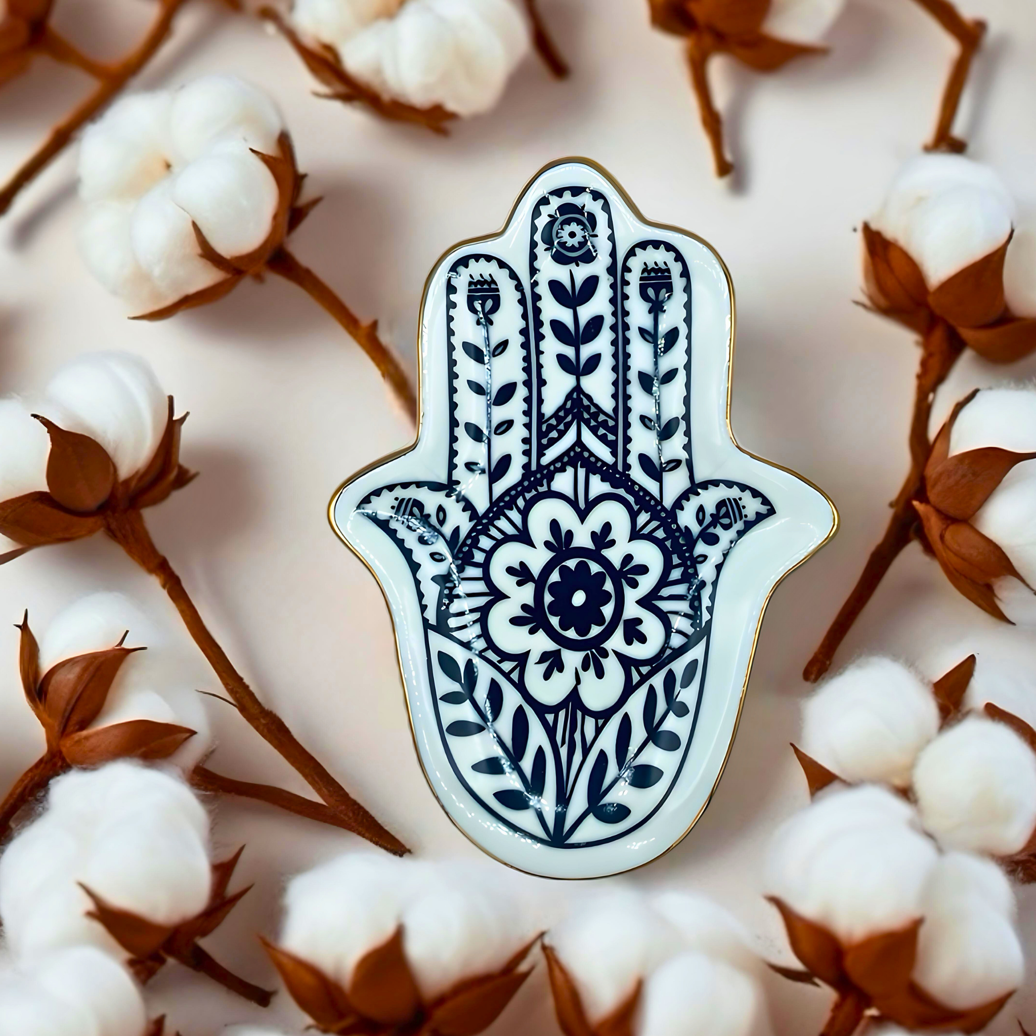 Decorative Hamsa hand pin on a background of cotton flowers