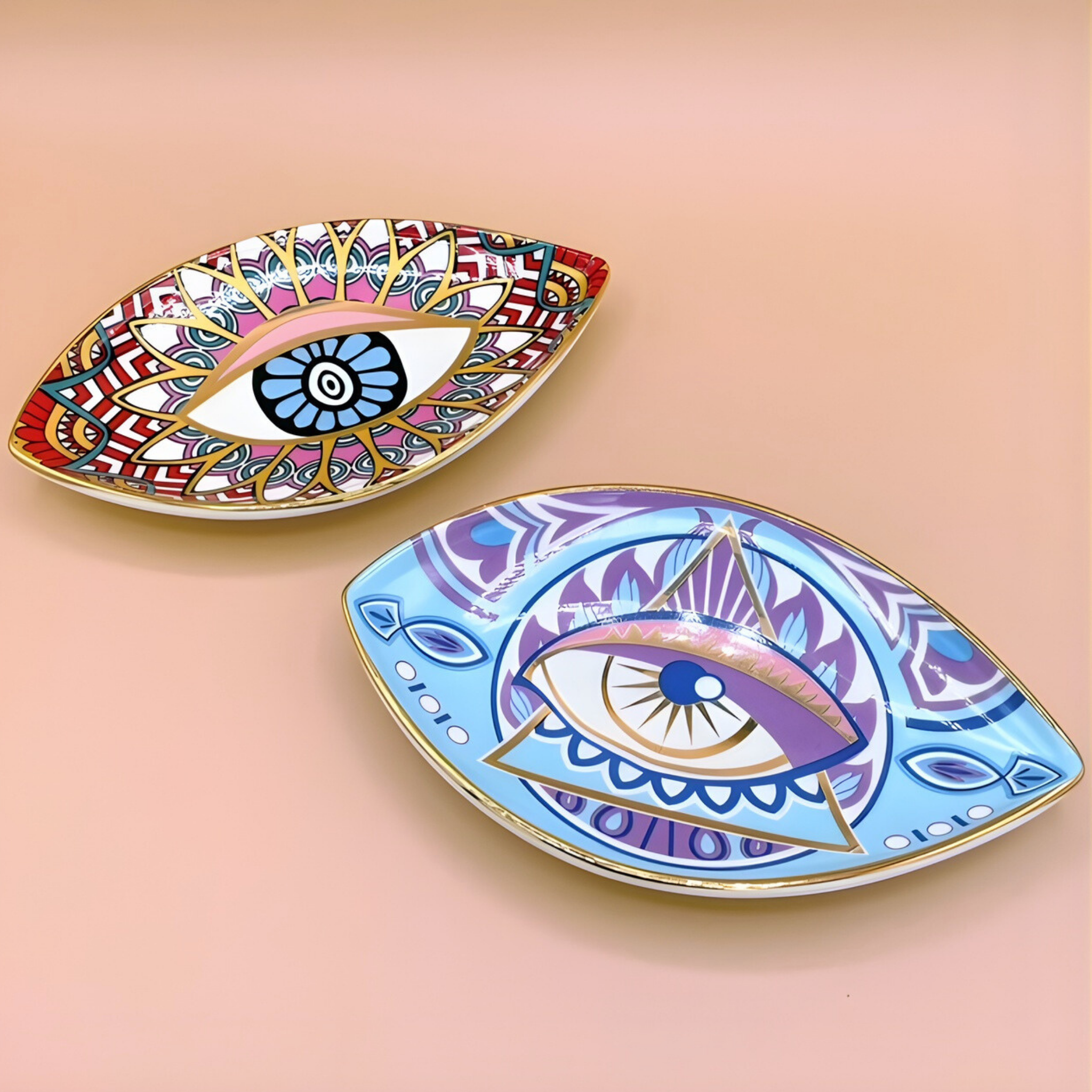 Two decorative plates with eye designs on a pink background