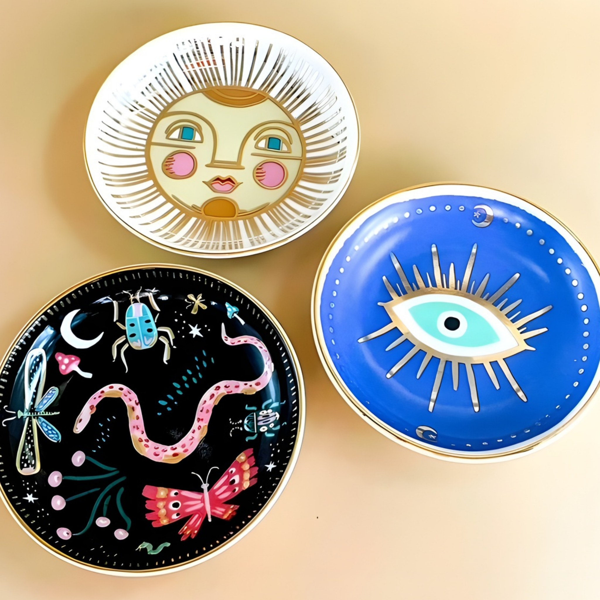 Three decorative plates with artistic designs on a beige background