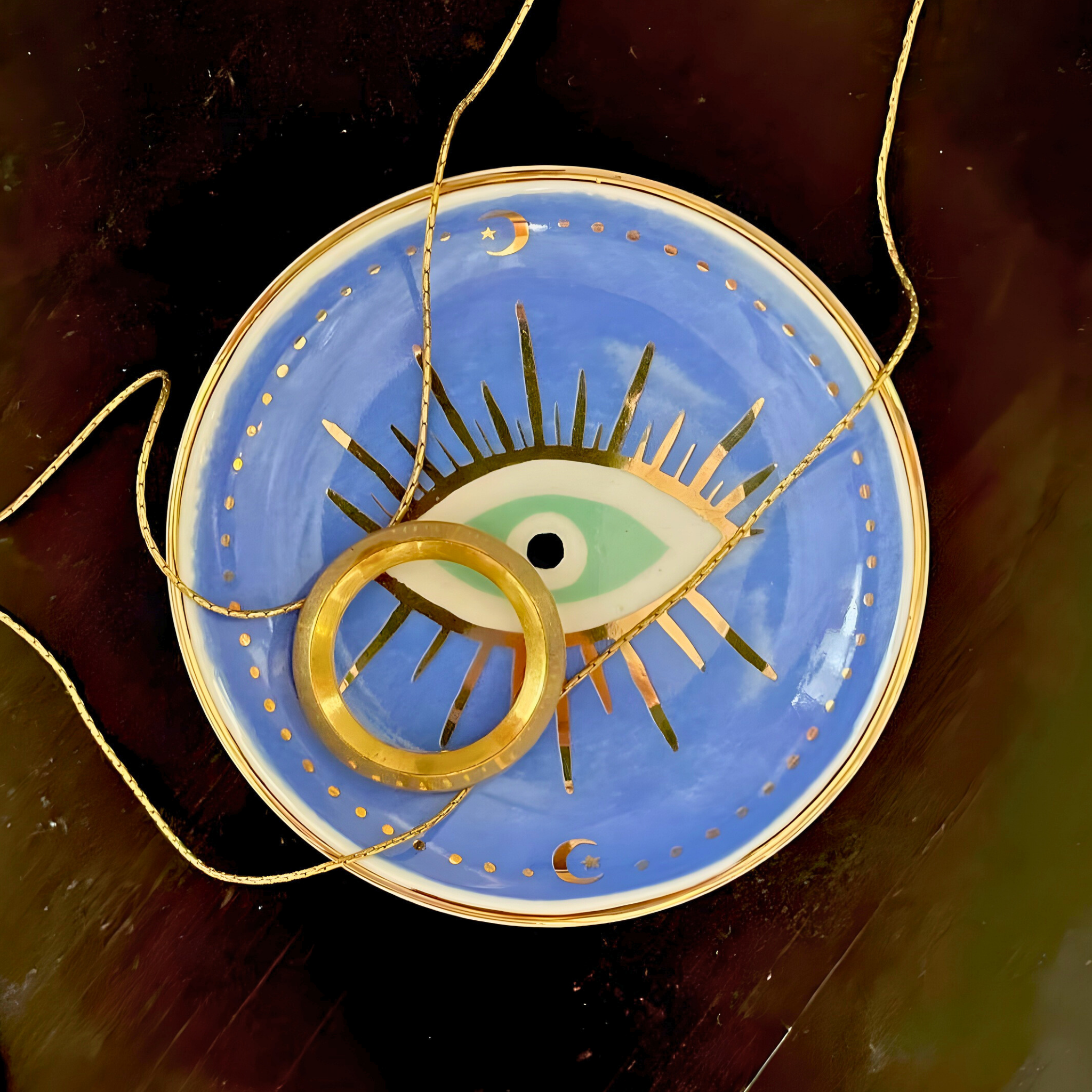 Decorative plate with eye design and gold accents on a blue background