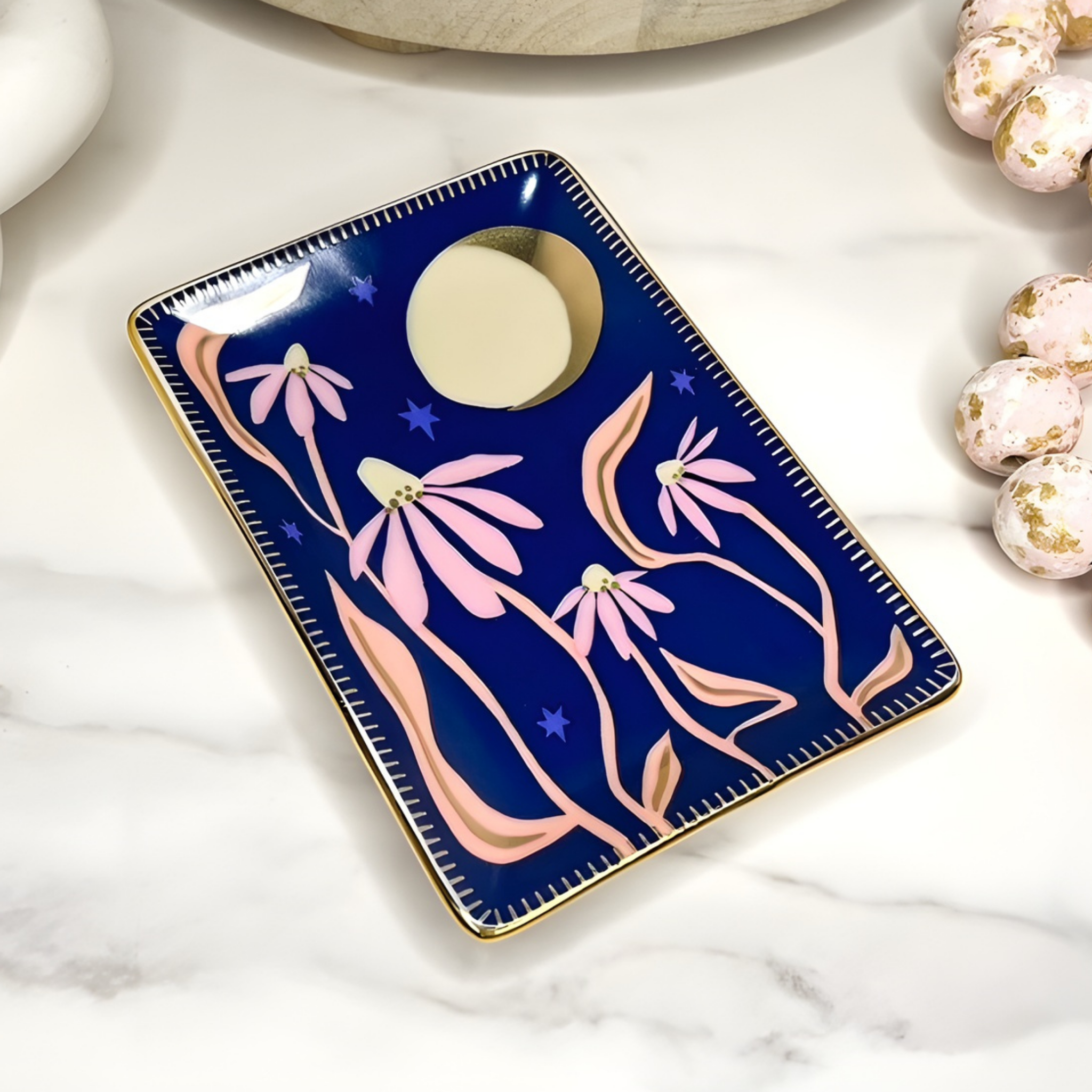 Decorative tray with pink floral design on a marble surface