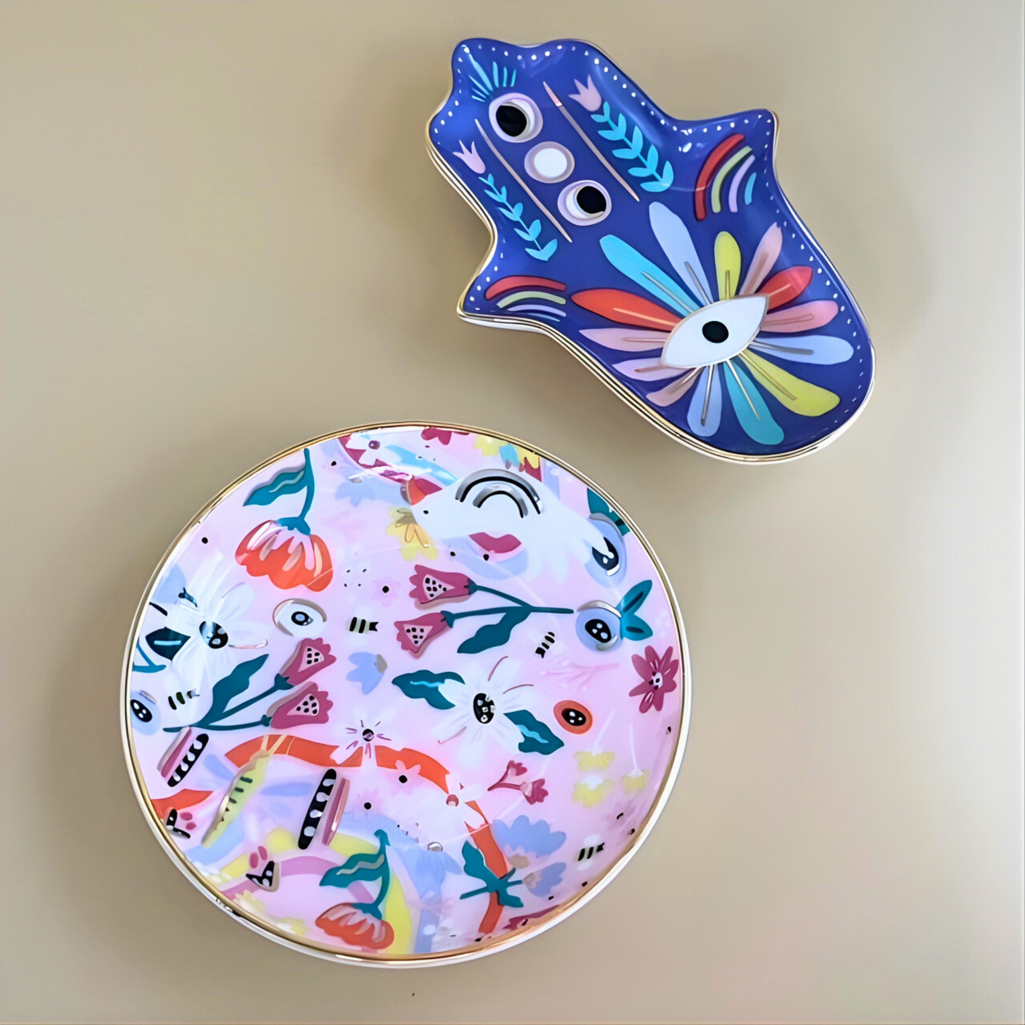 Two colorful ceramic plates with abstract designs on a beige background