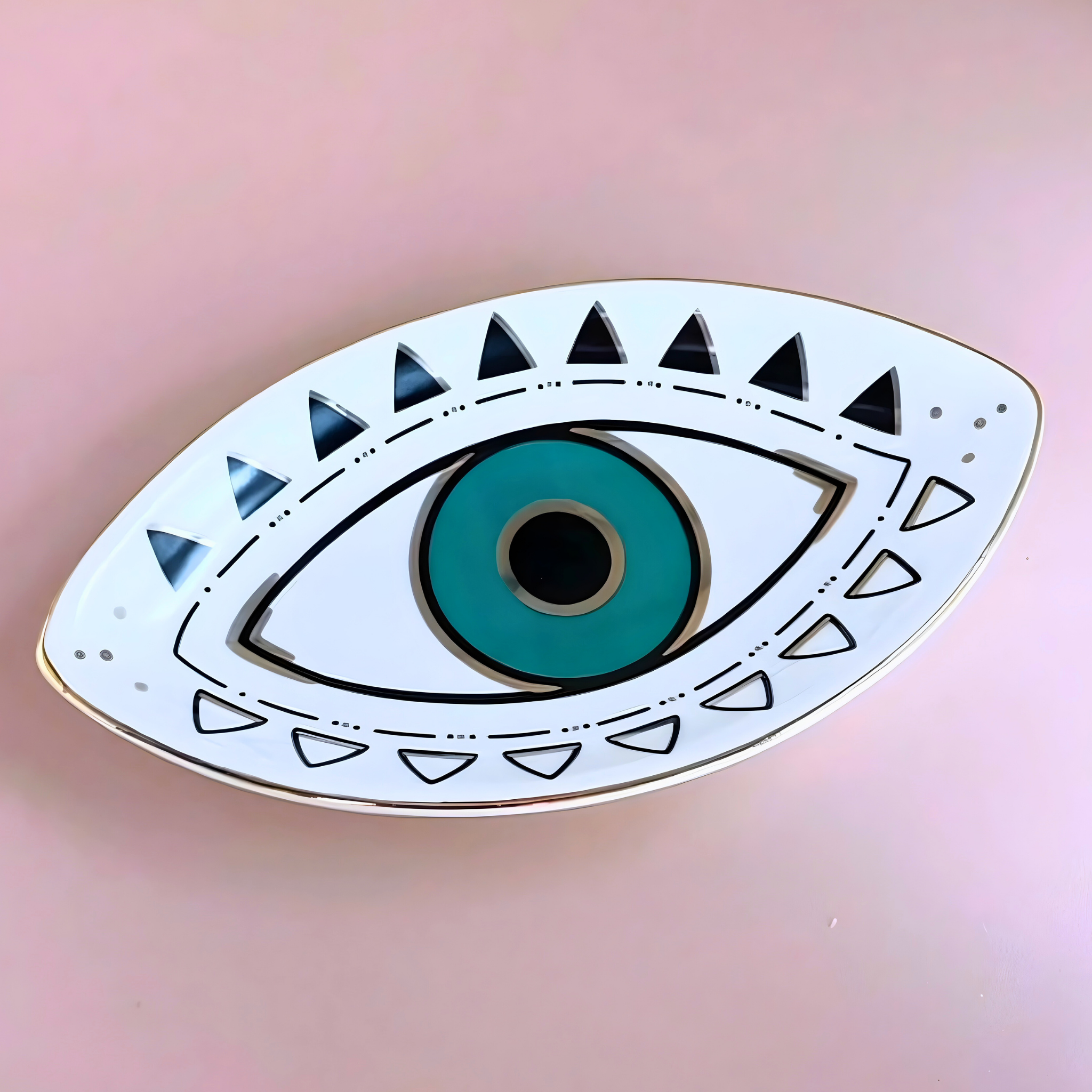 Decorative eye-shaped object with teal center and geometric patterns on a pink background