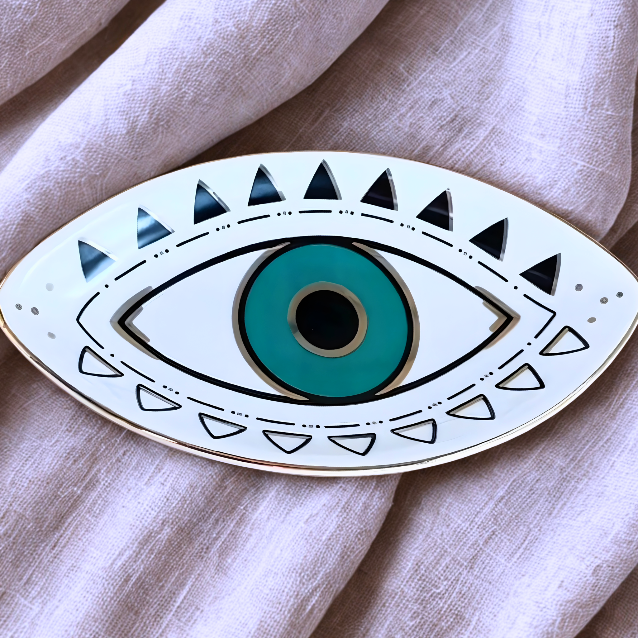 Decorative plate with eye design on a light fabric background