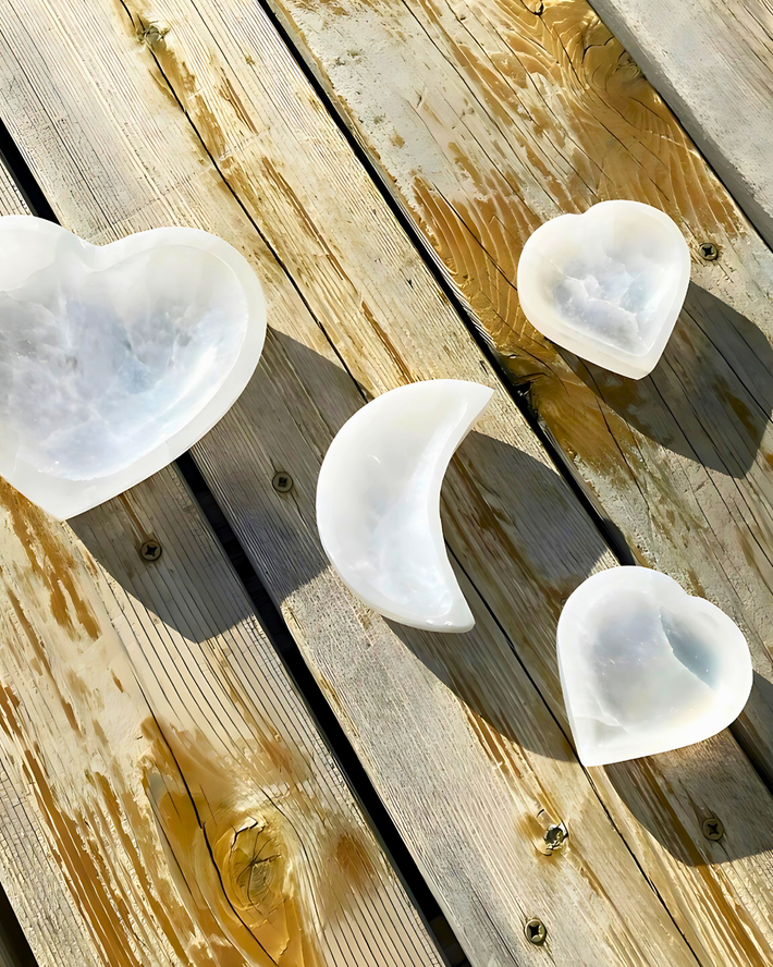White ceramic crescent moon-shaped objects on a wooden surface