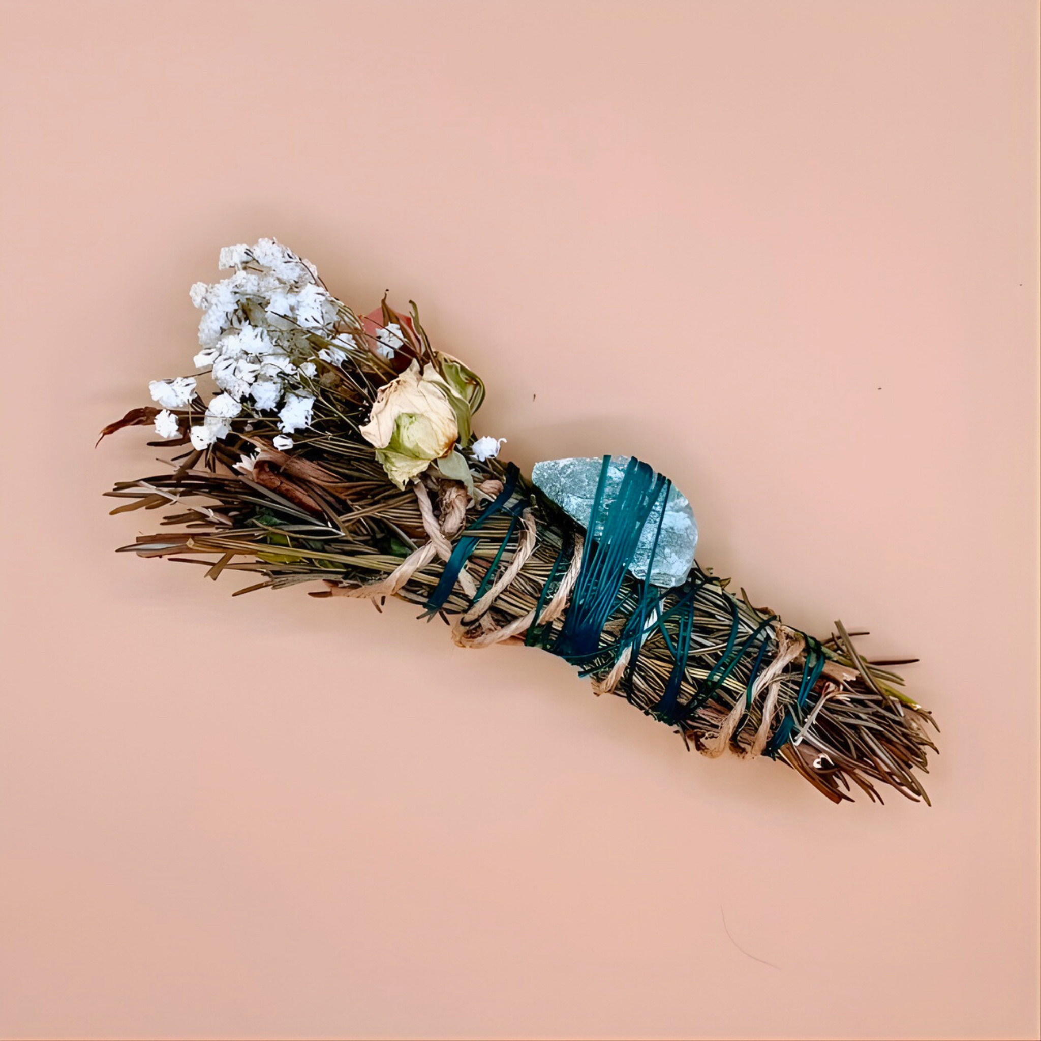 Smudging stick with dried herbs and flowers on a beige background
