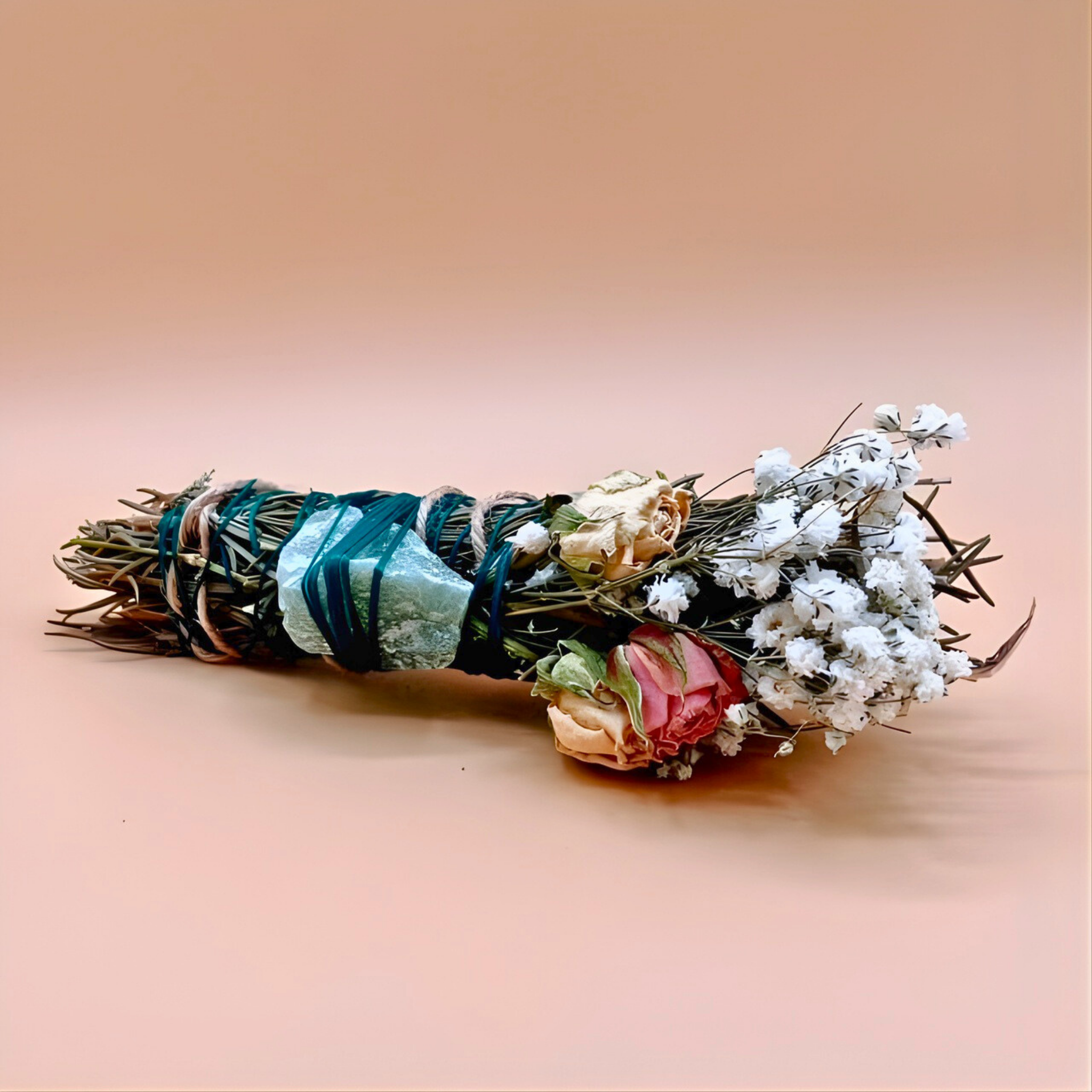 Bouquet of dried flowers and herbs tied together on a beige background