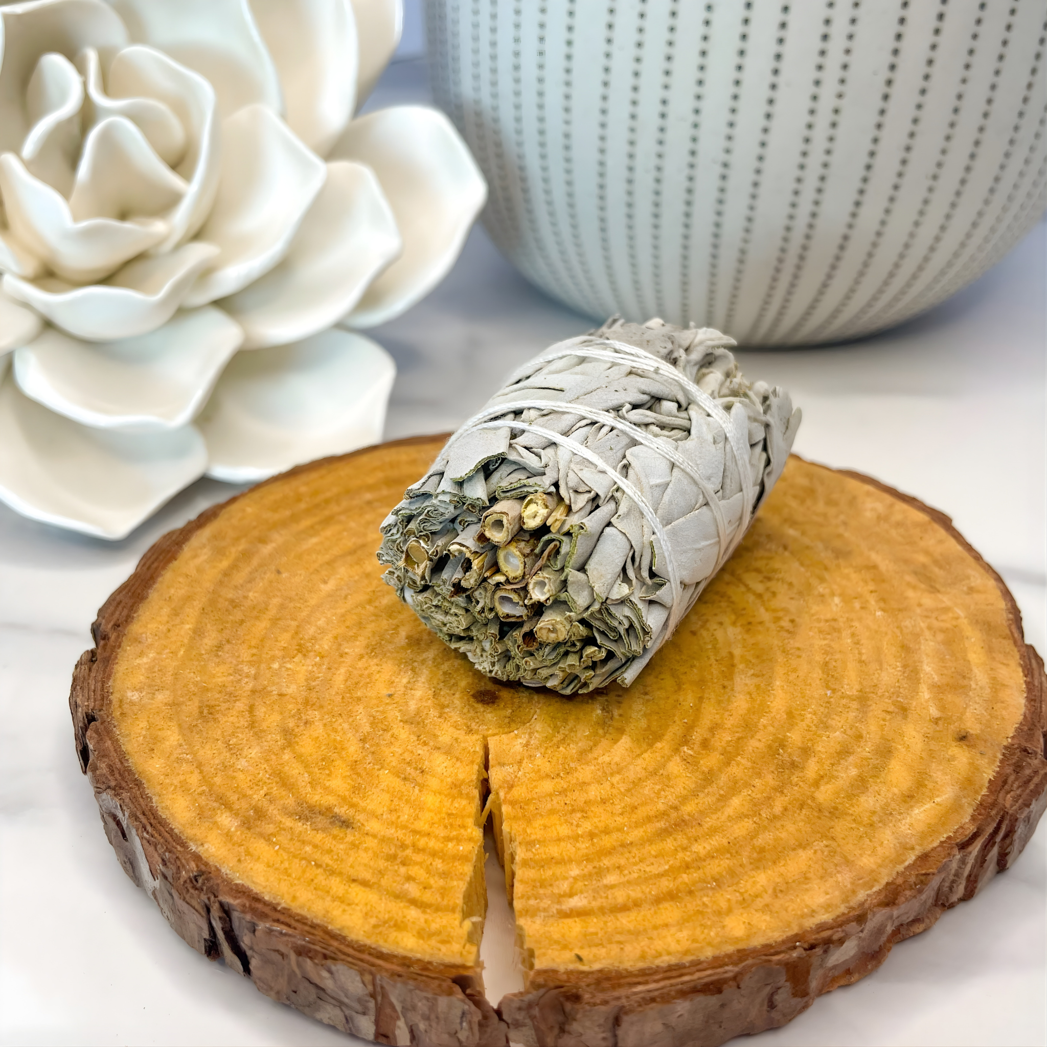 Rolled sage on a wooden coaster with decorative elements