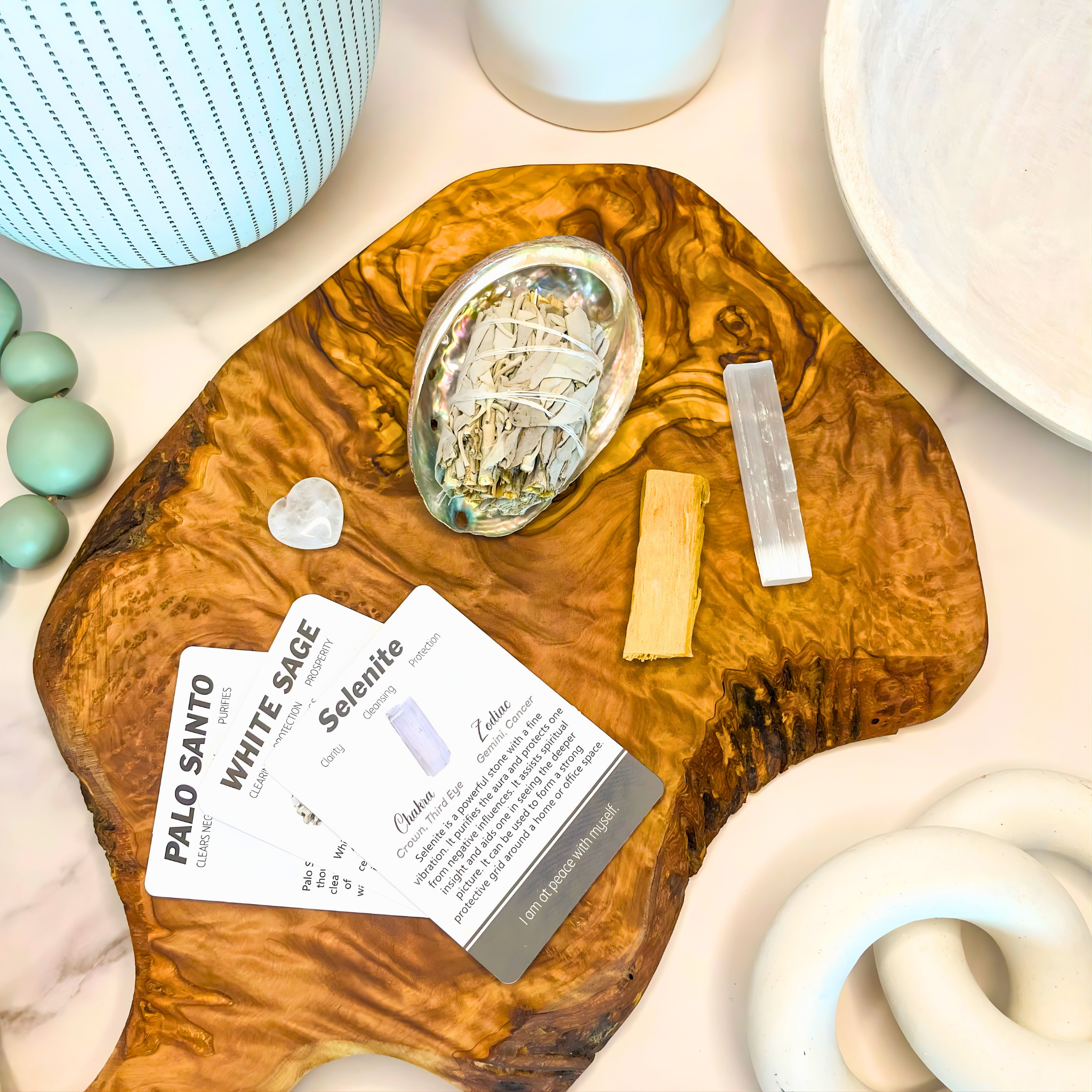 Wooden tray with crystals and cards on a marble surface