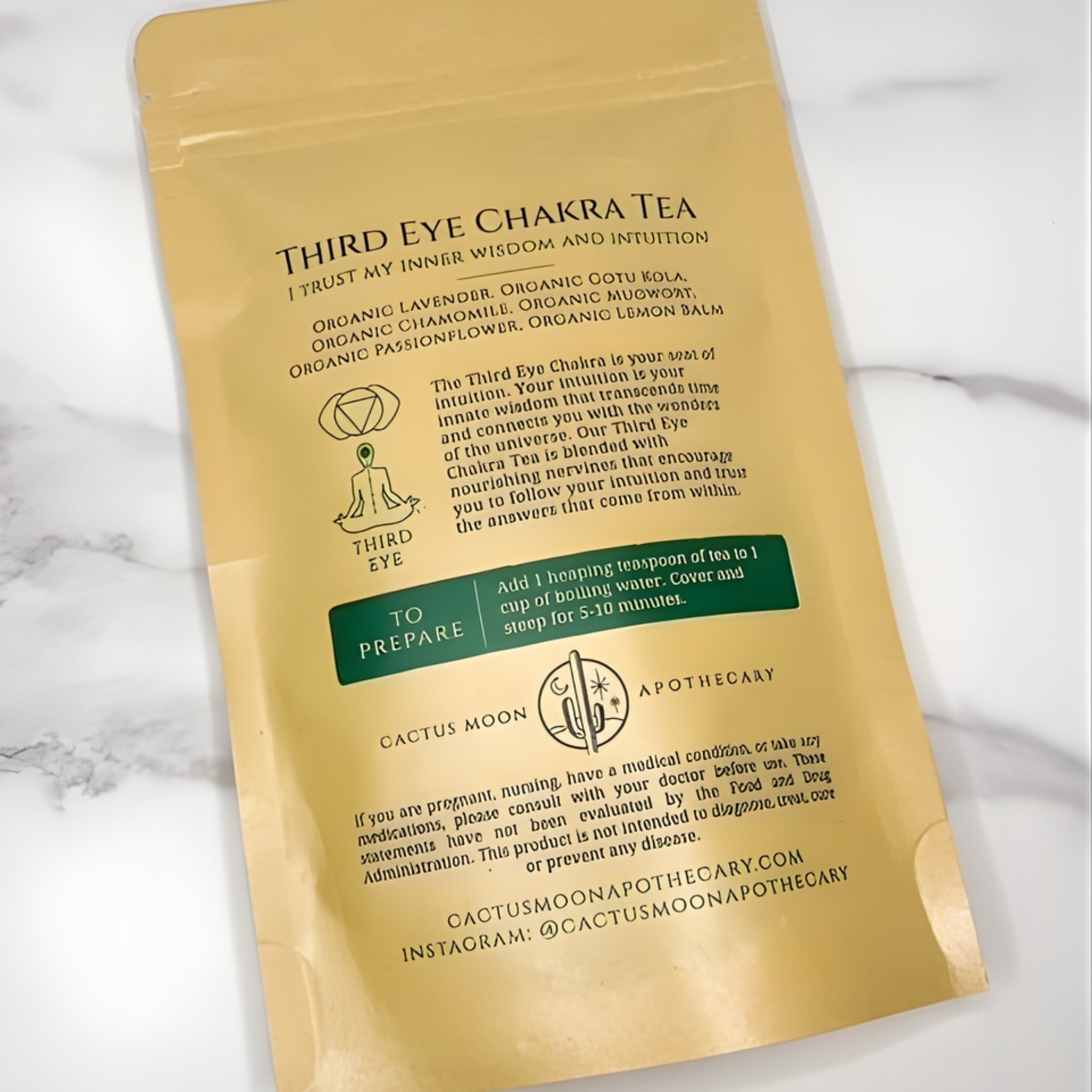 Gold package of Third Eye Chakra Tea with text on a white marble background